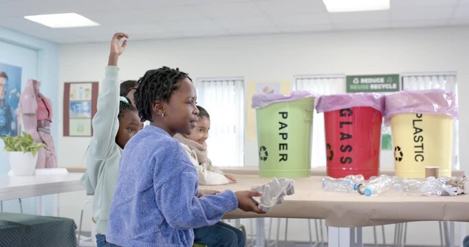 Children raising hands in school teacher taking egg carton and showing PAPER sorting into green bin