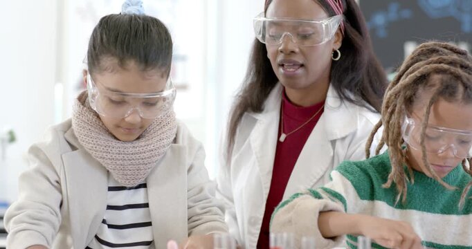 Lab class following teacher demo, using spatula, spreading powder in petri dishes at lab bench