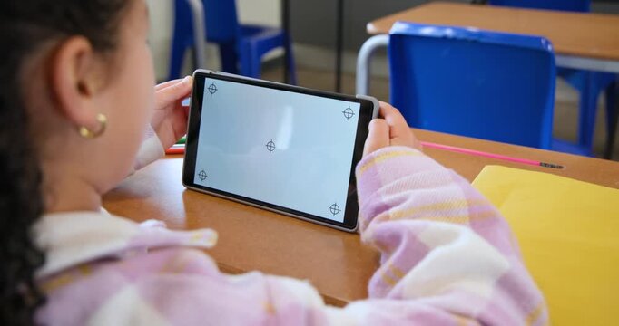 African American female youth adjusting tablet tilt to align markers at school desk, copy space