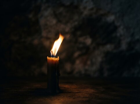 Burning Torch Illuminating Dark Cave Wall with Flickering Flames.