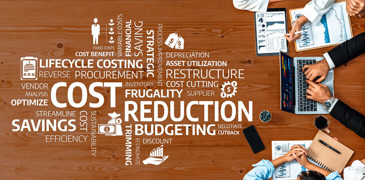 Aerial view of a team collaborating on cost reduction and budgeting strategies, showcasing key terms related to efficiency, savings, and financial management on a desk. Amity