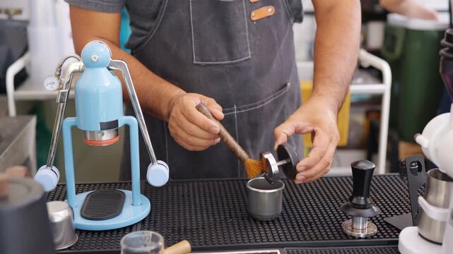 Small business entrepreneur coffee shop cafe restaurant. Asian man barista using manual espresso maker making freshly brewed coffee on bar counter. Waitress serving beverage drink to customer.