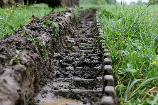 Close-up view of panzer tank tracks in muddy terrain