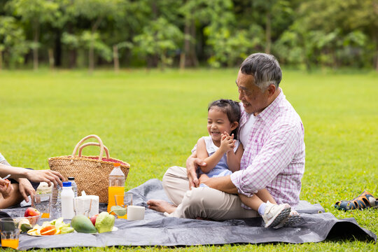 Girl run and hug, Little girl walking and spending time with father in the park. Happy Asian family having fun time on picnic at city nature park, outdoor activitie