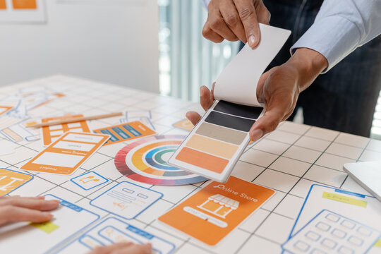 A UX design team collaborates with wireframes, interface cards, color palettes, and mobile app prototypes to improve user experience, design systems, product strategy, and digital innovation.