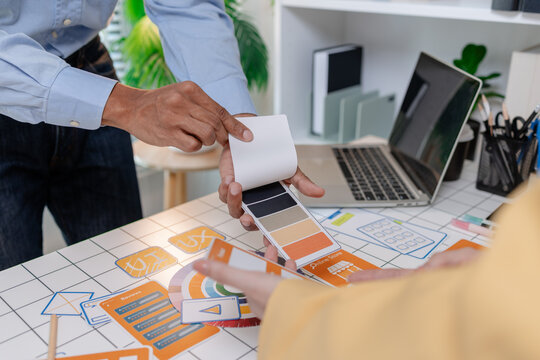 A UX design team collaborates with wireframes, interface cards, color palettes, and mobile app prototypes to improve user experience, design systems, product strategy, and digital innovation.
