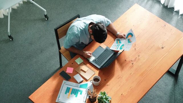 Skilled project manager walking at table while colleague brainstorm idea. Business team working together to plan marketing strategy while looking at data analysis or financial statistic. Convocation.