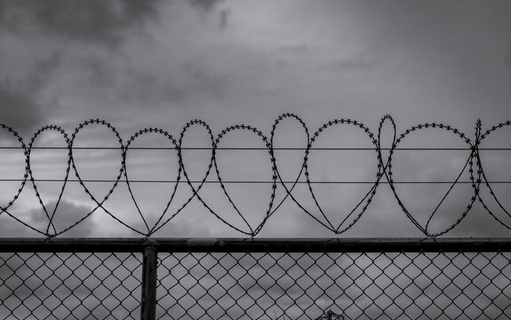 Prison security fence. Barbed wire security fence. Razor wire jail fence. Barrier border. Boundary security wall. Prison for arrest criminals or terrorists. Private area. Military zone concept.