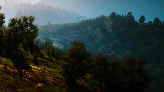 A view of a mountain landscape shows trees on a slope with sunlight filtering through. Hills rise in the background, creating a sense of depth and natural beauty.