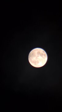 Bright full moon glowing in a dark night sky