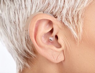 Fototapeta premium Modern hearing aid worn in human ear close-up.