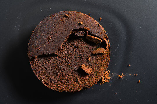Compressed Espresso Coffee Puck Resting on Dark Black Background with Copyspace