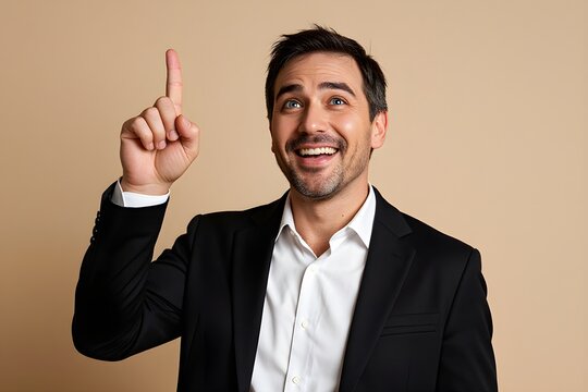 Man smiles broadly, pointing upward with one finger