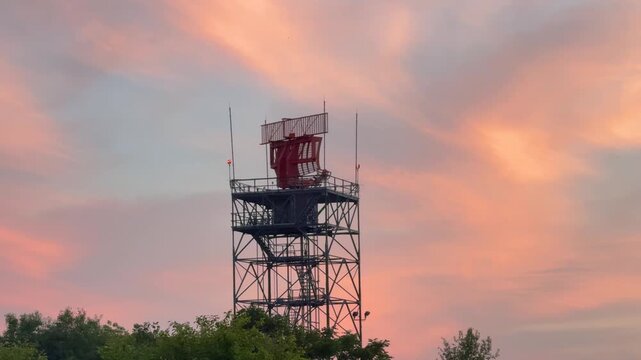 Airport radar tower spinning during a beautiful sunset