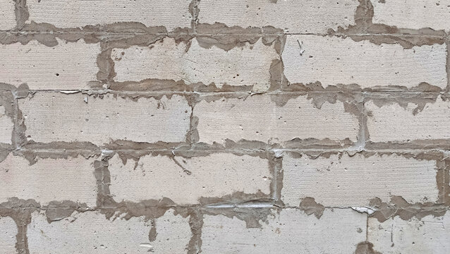 Unfinished lightweight concrete block wall texture with exposed mortar joints.