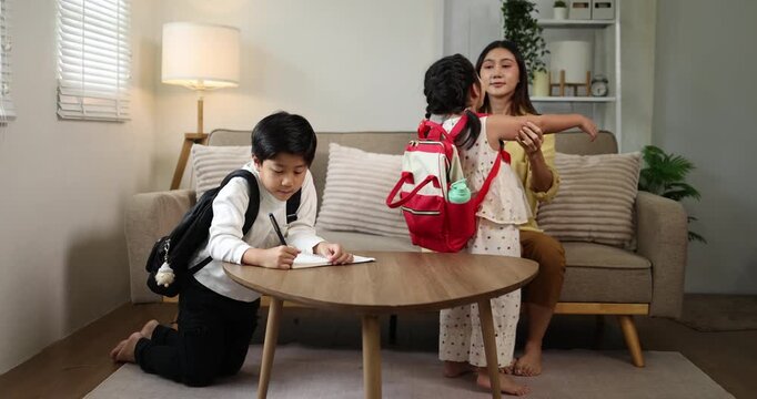 Asian mother engaging with her children, a boy and a girl, as they draw and color with marker pens on paper laid out on a low table, fostering a harmonious family environment