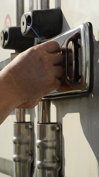 Vertical video of removing plastic security seal from truck door