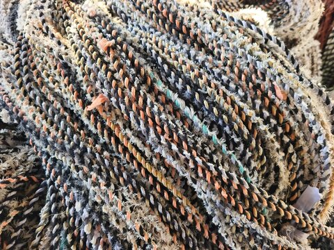 Detailed close up shot of a colorful woven mop head refill texture. Intertwined twisted yarn threads pattern photo for cleaning tools, houseware supplies, and hygiene concept backgrounds.