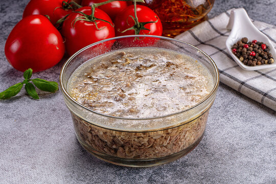 Jellied meat, or aspic, in glass bowl with tomatoes and spices