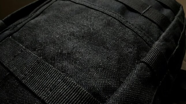 Close up texture of black fabric with straps and stitching detail