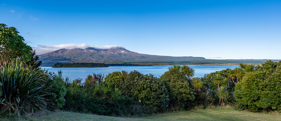 Lake Rotoaira, Mount Tongariro, Neuseeland, Cordyline australis, Motuapu Island, Vulkan mit Geothermaldampf und Wolken am See © stylefoto24