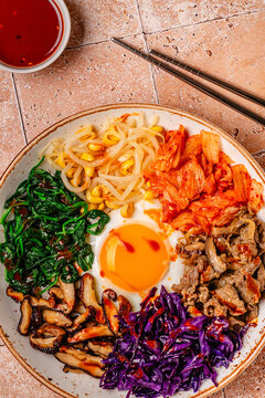 Bibimbap with colorful vegetables, beef, and egg