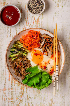 Bibimbap with colorful vegetables, beef, and egg