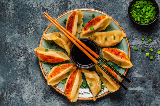 Dumplings served on a plate with green onions