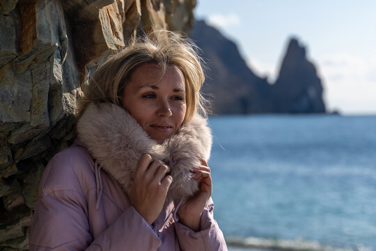 Woman Fur Collar Coastline: Winter portrait, seaside scenic beauty, casual wear.
