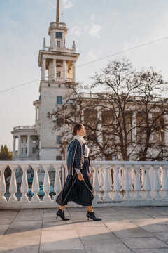 Woman walking building elegant woman in leather jacket walking past historic building on sunny day with copy space