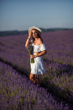 Woman lavender field summer portrait of a stylish lady holding flowers at sunset