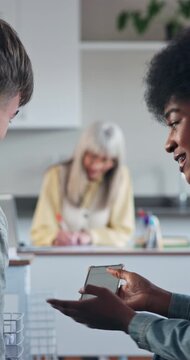 Student, friends and distraction with phone in classroom for addiction or bad behavior in lesson. Man, woman or learners laughing with smartphone in exam for cheating, disruption or cyberbullying