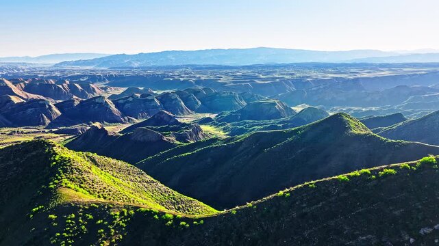 Aerial drone view of scenic green mountain valleys along the S101 highway in Xinjiang, China.