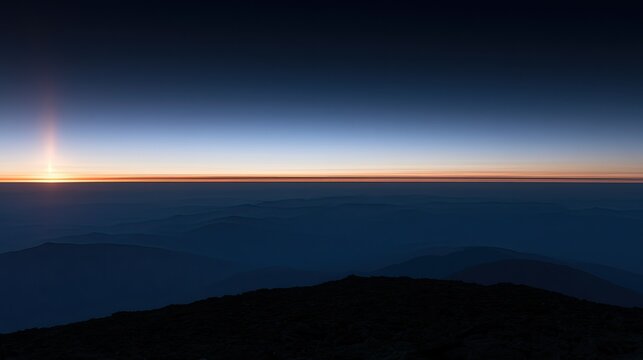 Horizon ablaze with sunrise over silhouetted mountain layers
