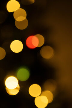 A blurry image of a Christmas tree with green and red lights