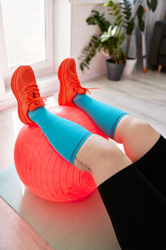 Person in sportswear exercising with fitness ball