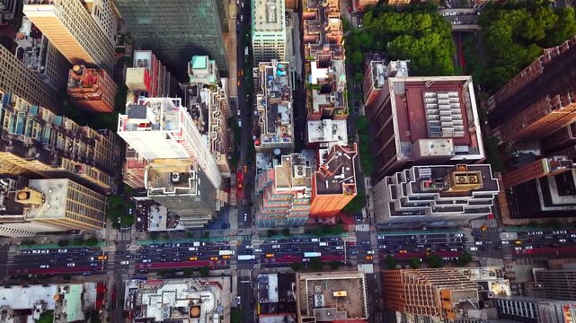 Aerial view of city intersection with traffic, Manhattan, New York. Rooftops, crosswalks and vehicles seen from directly above street grid.