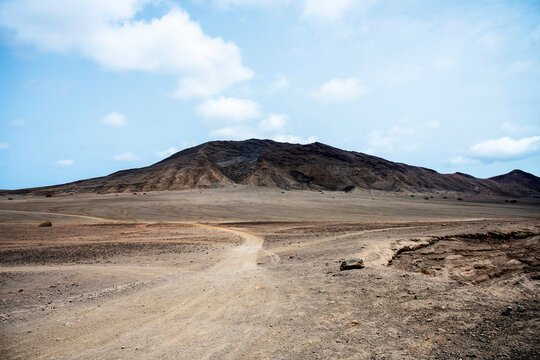 Winding dirt road through a remote volcanic landscape