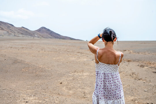 Woman from behind looking at desert landscape