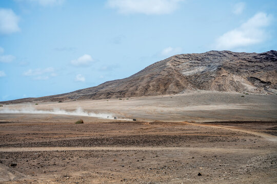 Off road vehicles race across a vast desert plain