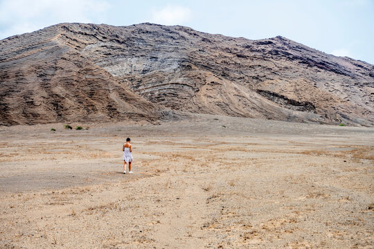 Woman walks alone in a vast arid valley