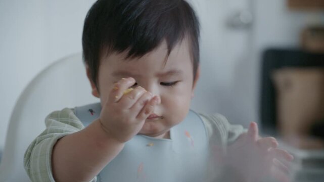 Cute Asian Toddler Eating Finger Food at Home, Healthy Childhood and Family Lifestyle in 4K