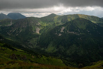 Obraz premium Dramatic mountain landscape with dark clouds and sunlit peaks in the Tatras