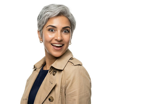 Woman smiles and looks at camera. She wears a light coat with short grey hair. Bright setting with clean background. Concept of fashion, beauty, personal styling