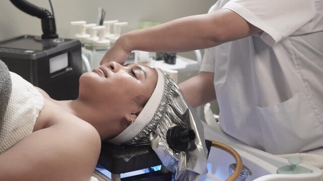 Japanese head spa therapist prepares a heated steaming cap for deep conditioning and scalp therapy during a luxury salon treatment at japanese head spa..