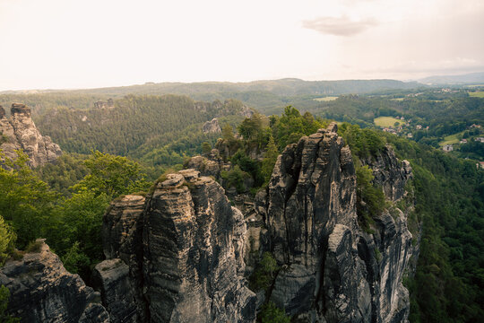 eiter Panoramablick von oben auf die spektakul&auml;ren Sandsteinfelsen der Bastei und die weitl&auml;ufige Waldlandschaft im Nationalpark S&auml;chsische Schweiz.