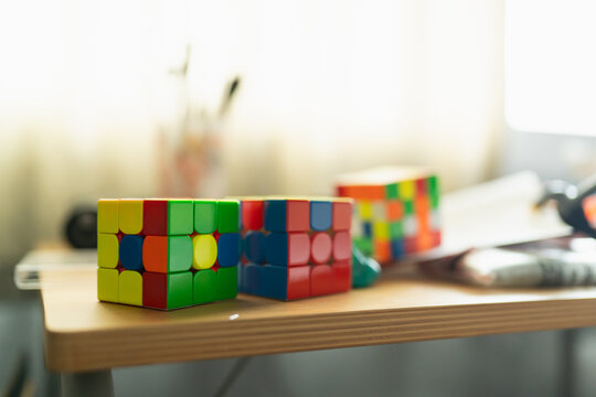 Bangkok, Thailand - July 23, 2026 : Unsolved Rubik's Cubes Mixed Colors Puzzle Toys Resting on Wooden Table.