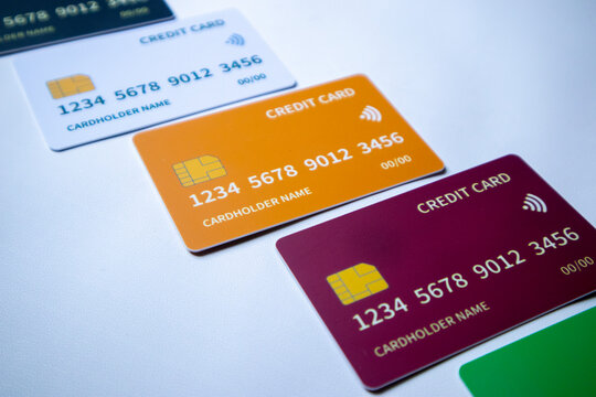 Macro angled diagonal row of multi-colored credit and debit cards on a white surface