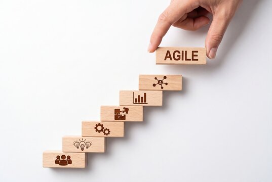 Hand placing wooden block labeled agile onto staircase concept representing business growth