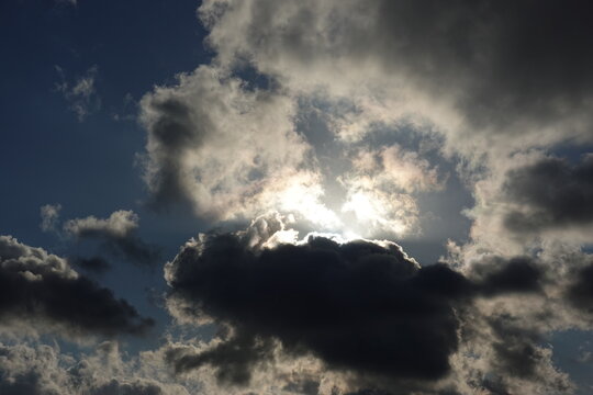 Dramatic sun rays breaking through dark clouds in a moody sky